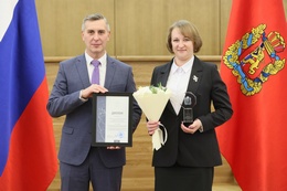 Председатель Шапкинского сельского Совета депутатов Елена Машукова получает награду от председателя Законодательного собрания Красноярского края Алексея Додатко.